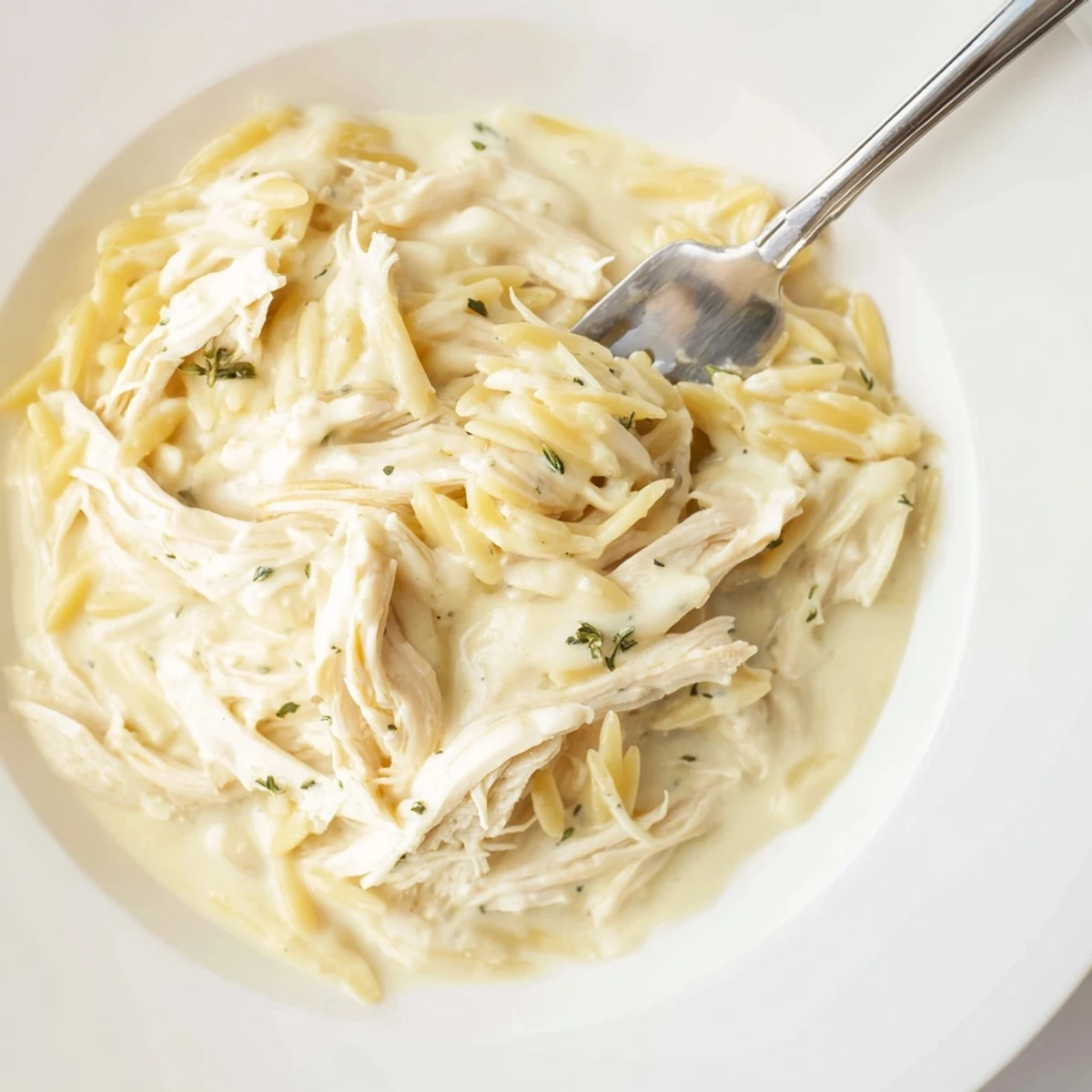Creamy Lemon Herb Chicken Orzo served in a bowl, showcasing vibrant herbs and pasta.  