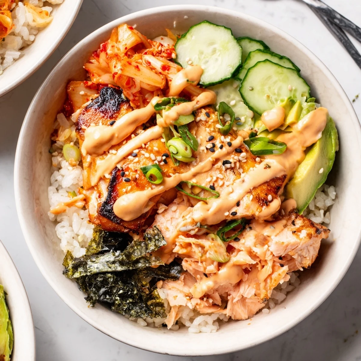 Crispy Salmon Rice Bowl topped with spicy mayo, garlic, and vibrant kimchi flavors.