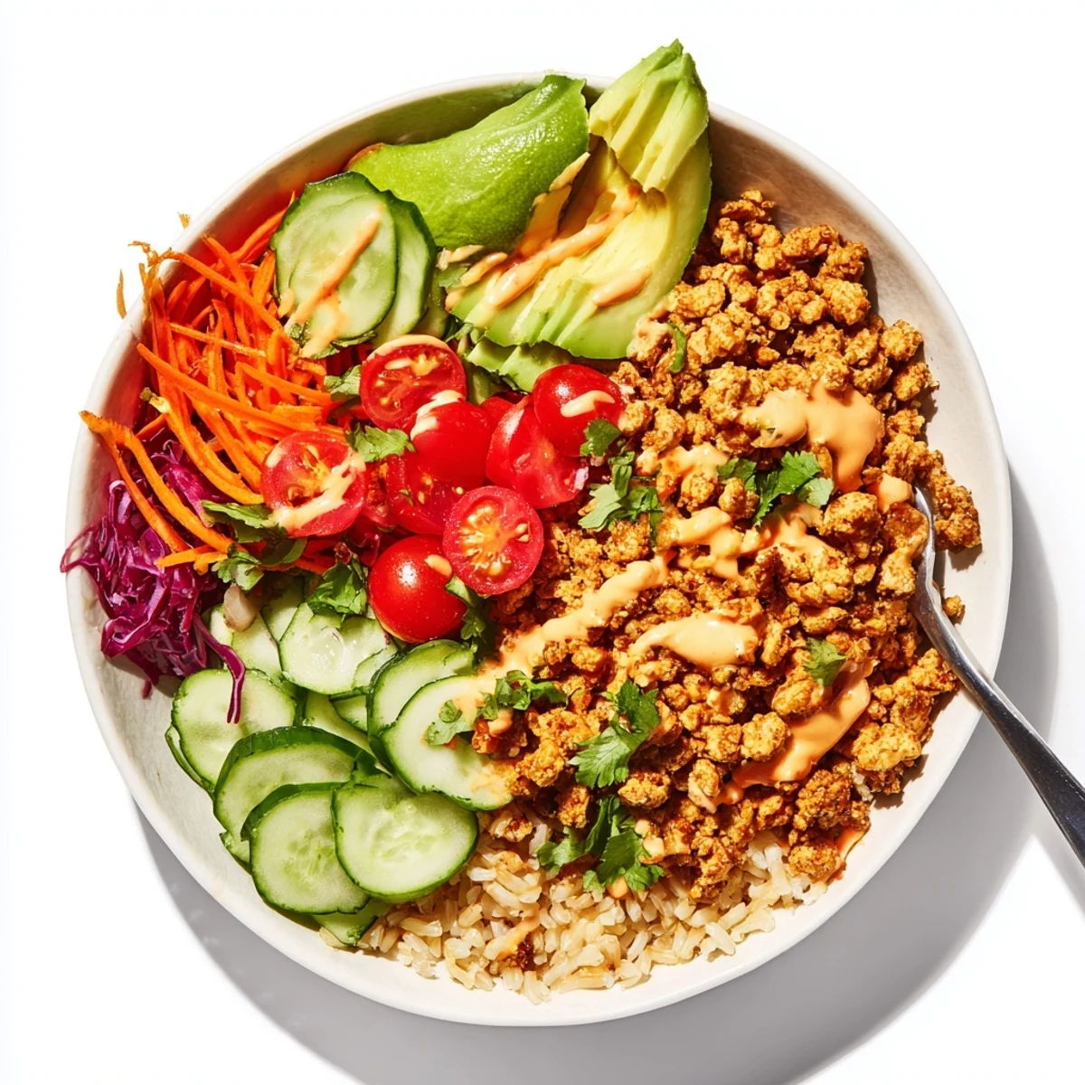 Vibrant plant-based meat bowl topped with fresh vegetables and zesty lime wedges.  