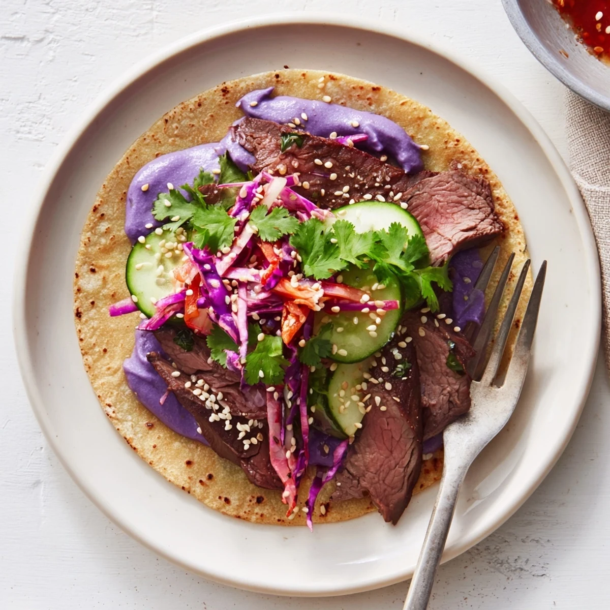 Close-up of vibrant Global Street-Food Fusion Tacos drizzled with creamy ube sauce.  