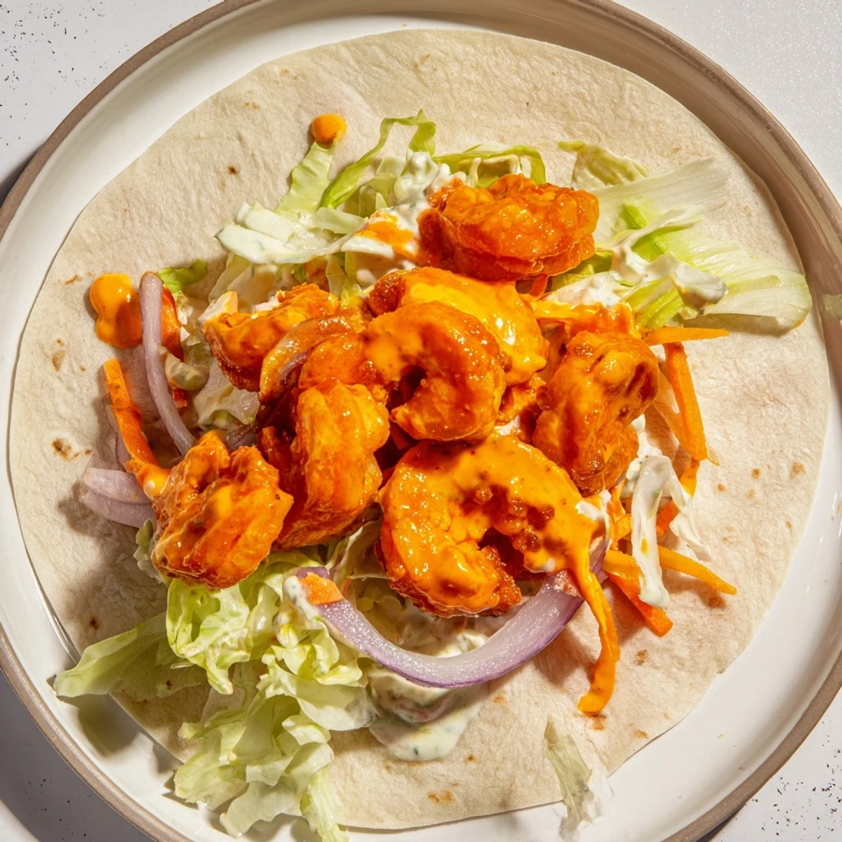 Close-up of Buffalo Shrimp Wraps: imagine tender shrimp coated in spicy sauce, ready to eat!