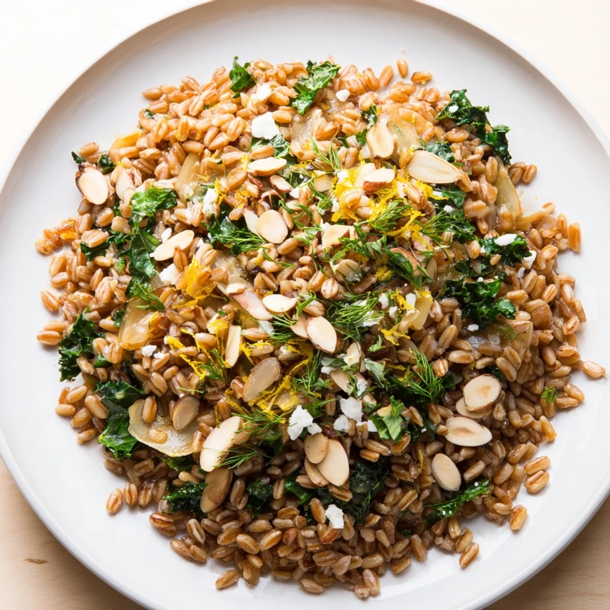 This image shows a beautifully plated Warm Farro & Greens Pilaf, garnished with toasty almonds.