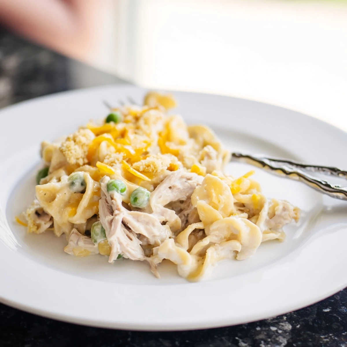 A comforting, flavorful photo of warm Creamy Tuna Noodle Casserole with a bubbly, golden crust.