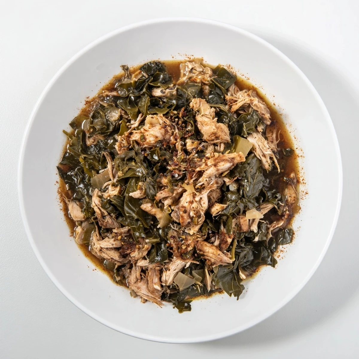 Close-up of hearty Southern style collard greens with visible smoked turkey, ready to eat.
