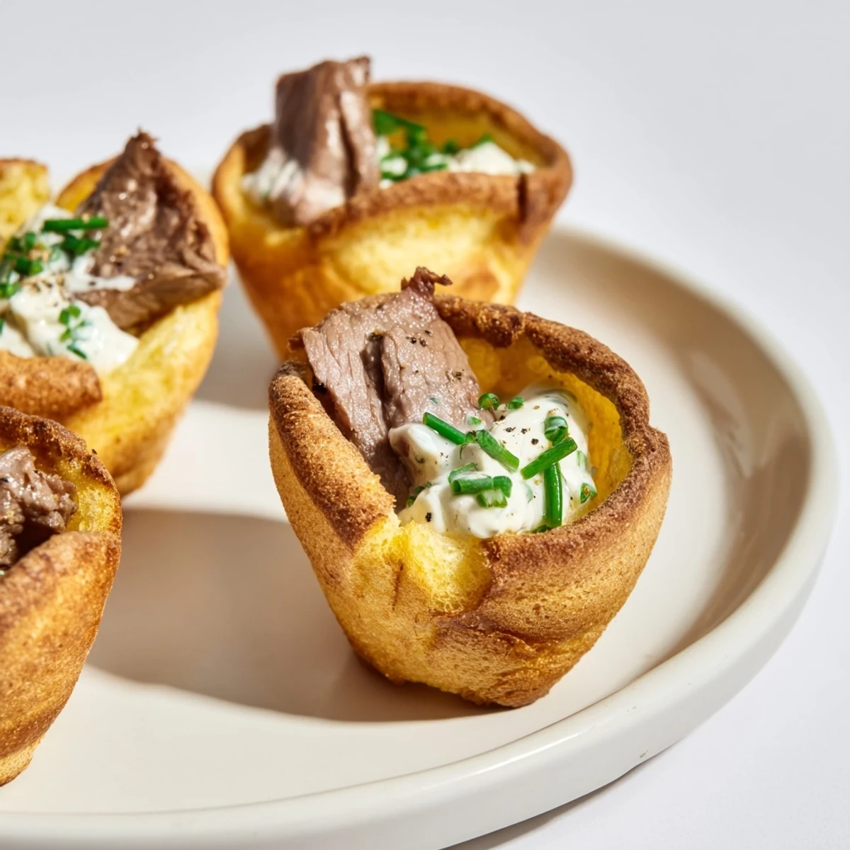 Golden, puffed Express Holiday Yorkshire Pudding Bites filled with tender roast beef and creamy horseradish sauce.