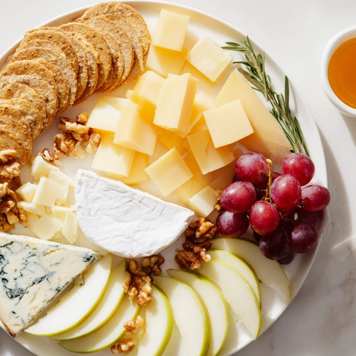 Assorted cheeses, crackers, and fruits beautifully compose this elegant Cheese Plate appetizer, ready to serve.