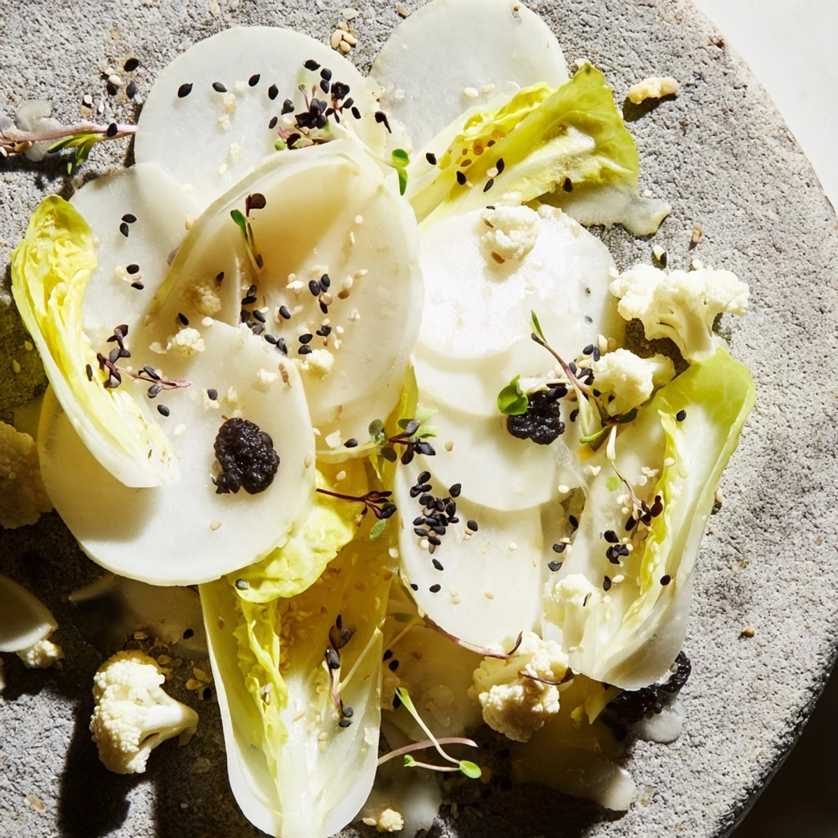 Chilled "Tundra Trek" appetizer features crisp, pale vegetables artfully arranged on cold stone.