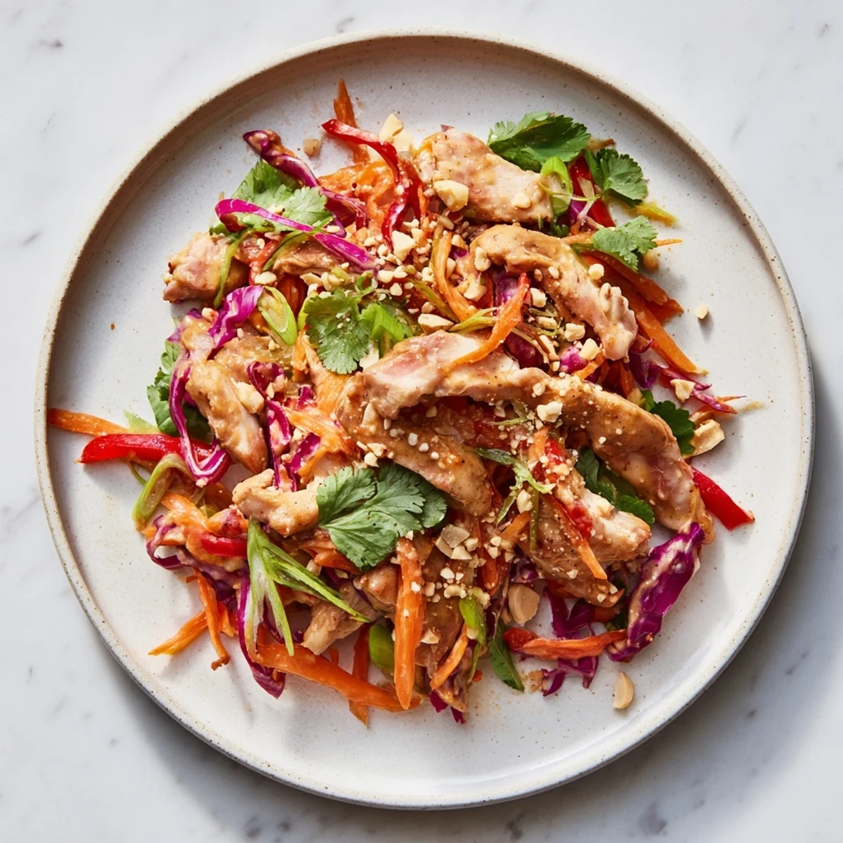 Close-up of a bright Carrot Ribbon and Chicken Slaw salad, showcasing the tender chicken and veggie textures.