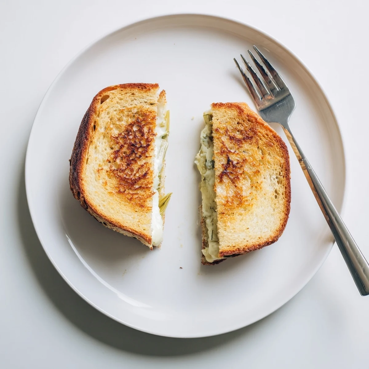 Golden, buttery sourdough slices stuffed with creamy melted Havarti and sweet, caramelized leeks in this hearty grilled cheese.  