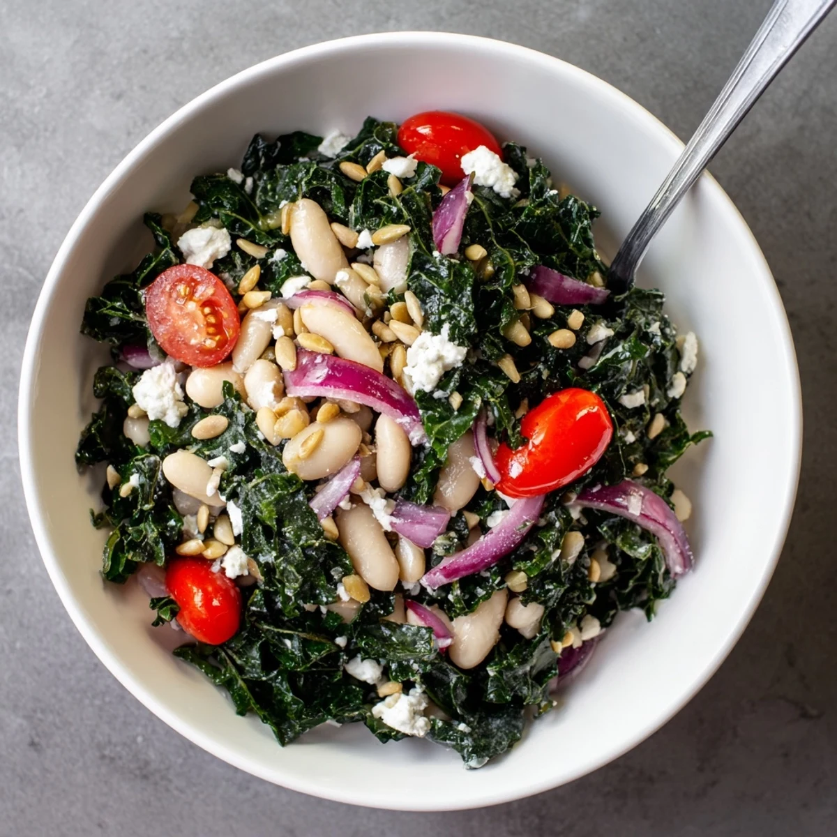 A vibrant Mediterranean White Bean and Kale Salad served in a white ceramic bowl, perfect for a healthy, vegetarian lunch or side dish.