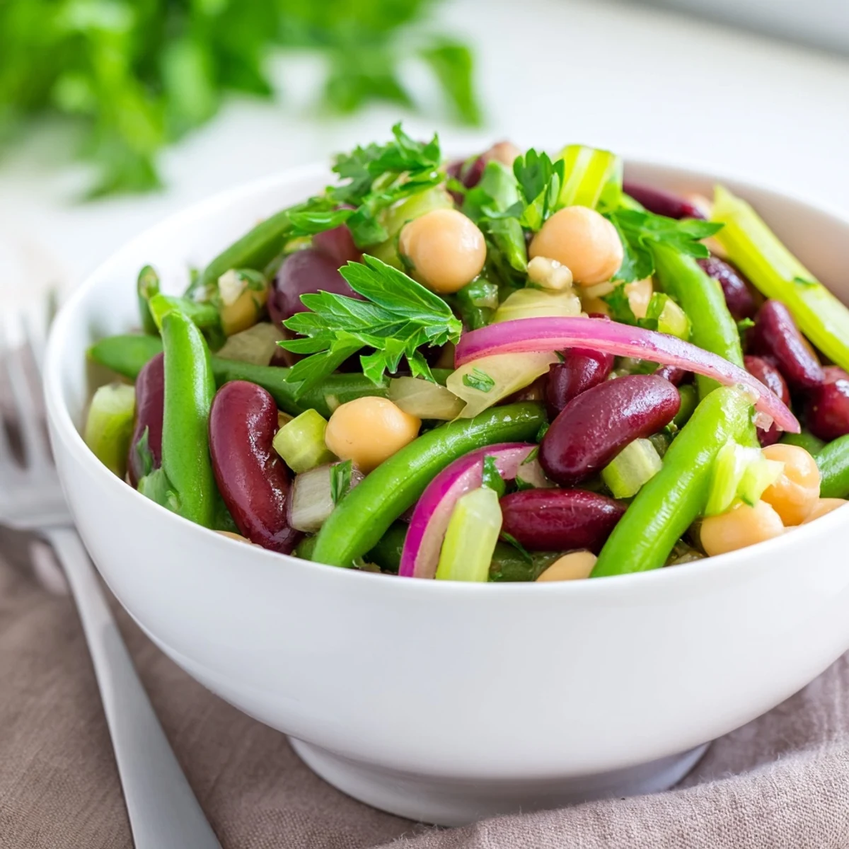 Vibrant Three-Bean Salad bursting with fresh herbs and tender beans, ideal side.