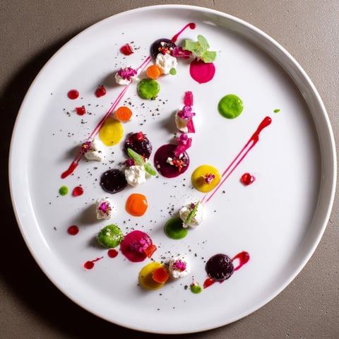 The Pointillism Dot Matrix appetizer features vibrant veggie purees dotted on the plate.