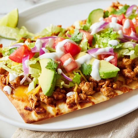 Golden, oven-baked Spicy Turkey Taco Flatbread awaits fresh toppings like diced tomatoes.