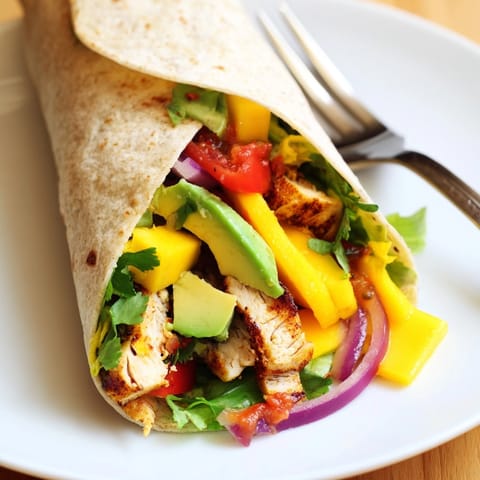Delicious, homemade Mango Avocado Chicken Burritos ready to eat with optional spicy salsa.