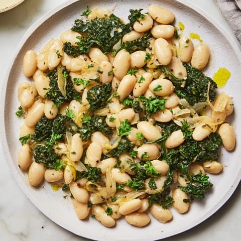 A steaming bowl of Garlicky Beans with Winter Greens, vibrant and ready to warm you.