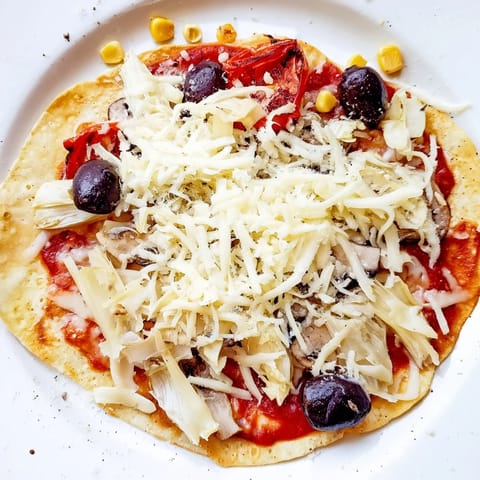 Warm and crispy tortilla pizza, a speedy meal with melty cheese and colorful toppings.
