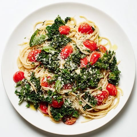 A delicious close-up of the flavorful, easy one-pot spaghetti, featuring vibrant tomatoes and greens.