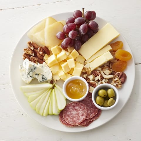 A beautifully arranged Moonlight Picnic Board, showcasing artisan cheeses, fruits, and charcuterie awaiting enjoyment.