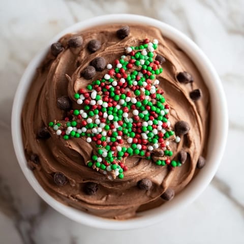 Festive Tree Brownie Dip, swirled and topped with holiday sprinkles, is perfect for dipping graham crackers.