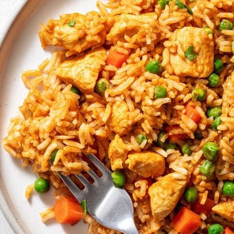 Colorful butter chicken fried rice in a skillet with tender chicken pieces and vibrant vegetables, steaming hot and ready to serve.