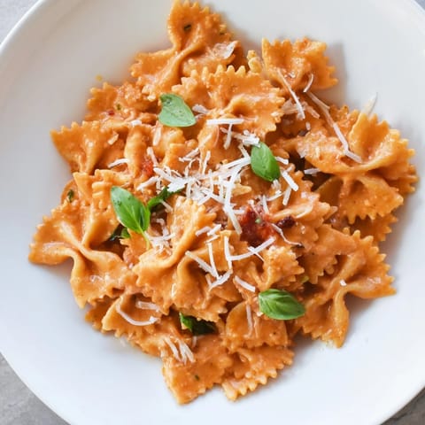 Steaming bowls of Tomato Basil Bowtie Pasta feature al dente farfalle coated in a silky tomato cream sauce, perfect for a quick vegetarian weeknight dinner.  