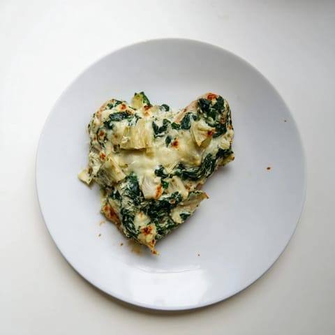 Spinach & Artichoke Chicken Bake features baked chicken topped with a tangy Greek yogurt and cheese mixture studded with greens.