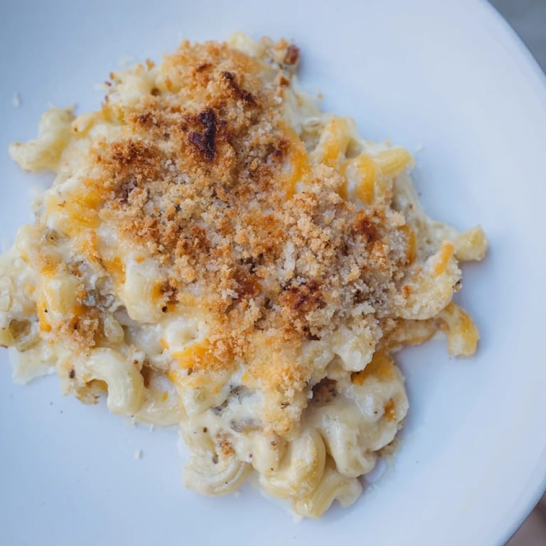 A close-up of creamy baked macaroni and cheese, boasting a crispy, golden-brown topping.