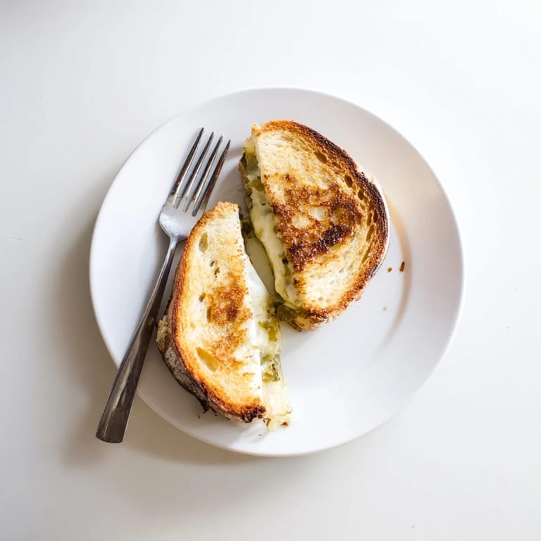 A decadent Havarti & Caramelized Leek Grilled Cheese with crispy golden crust, oozing cheese and sweet leeks on artisan bread.
