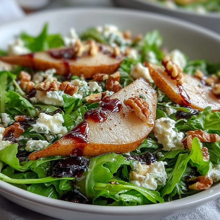 Freshly tossed Arugula and Pear Bowl featuring ripe pear wedges, crumbled goat cheese, and a light honey balsamic drizzle.